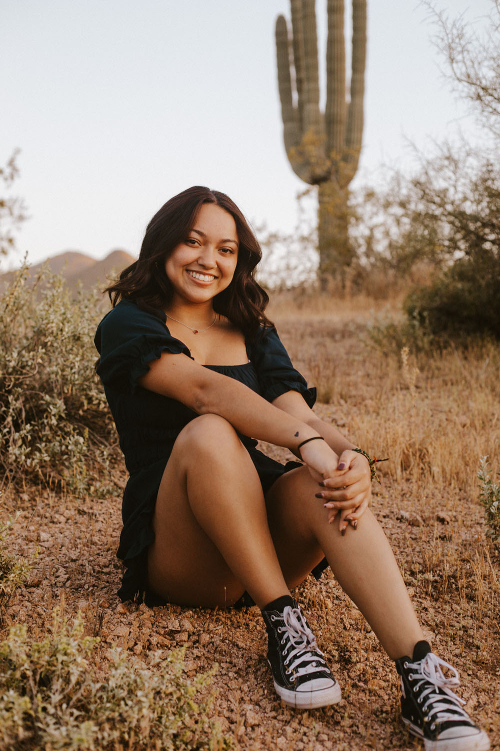 Malaya smiling in front of the camera in a desert landscape