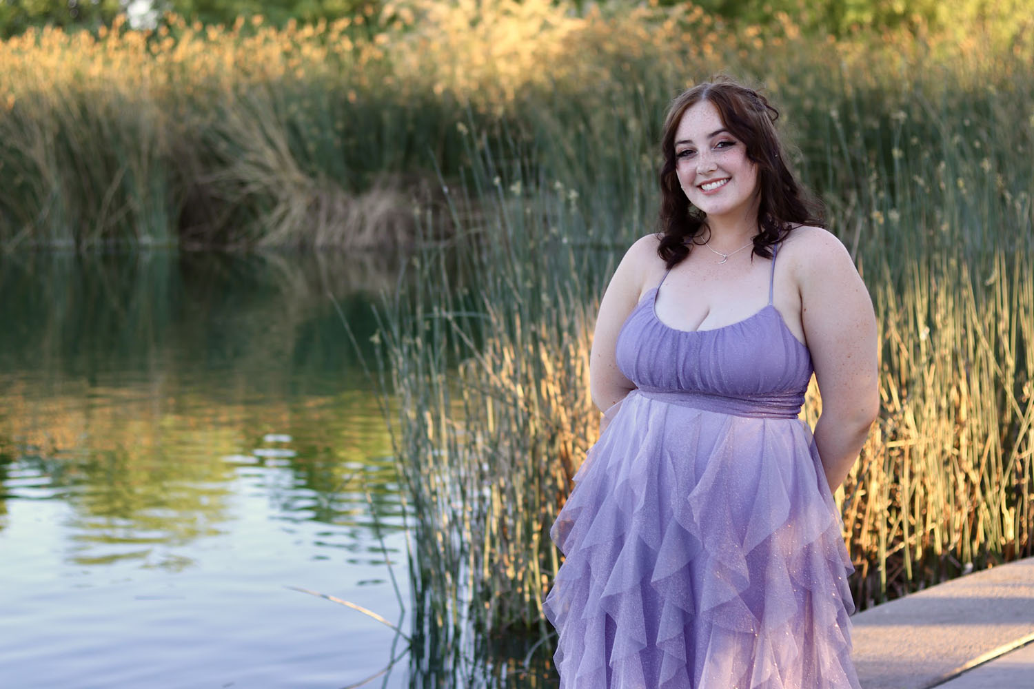 Young girl ready for prom in front of a pond