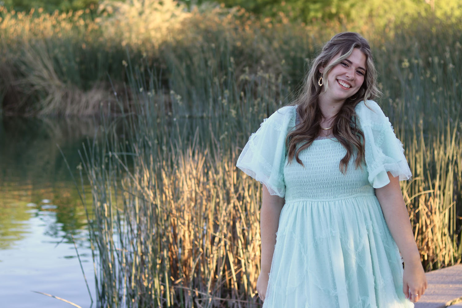 Young girl ready for prom in front of a pond