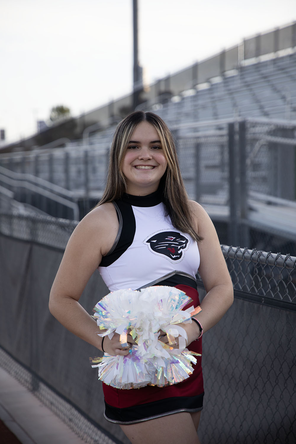 Mailee smiling by the bleachers