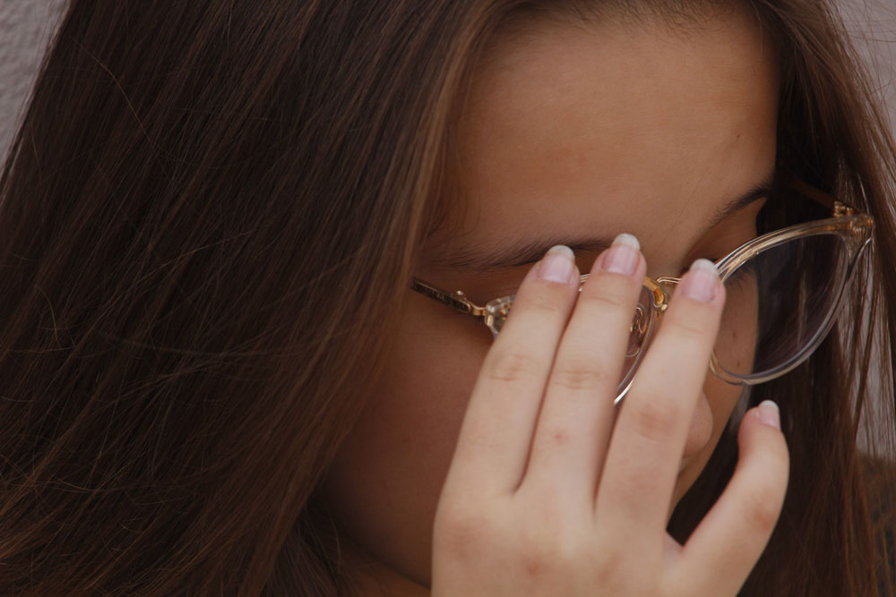 girl touching her glasses