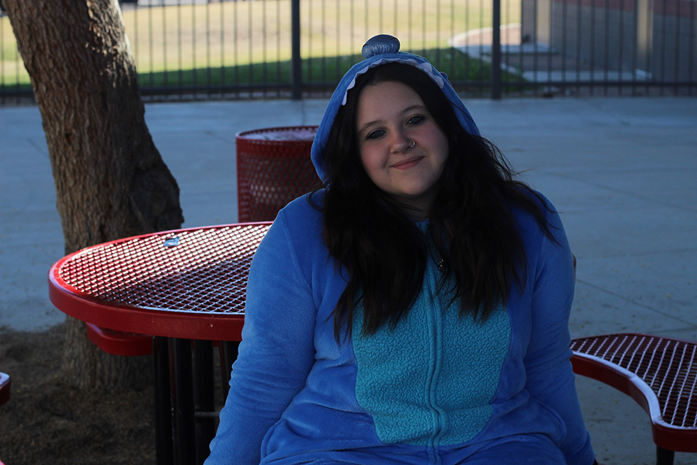 Kaydence sitting on a bench with a stitch onesie.