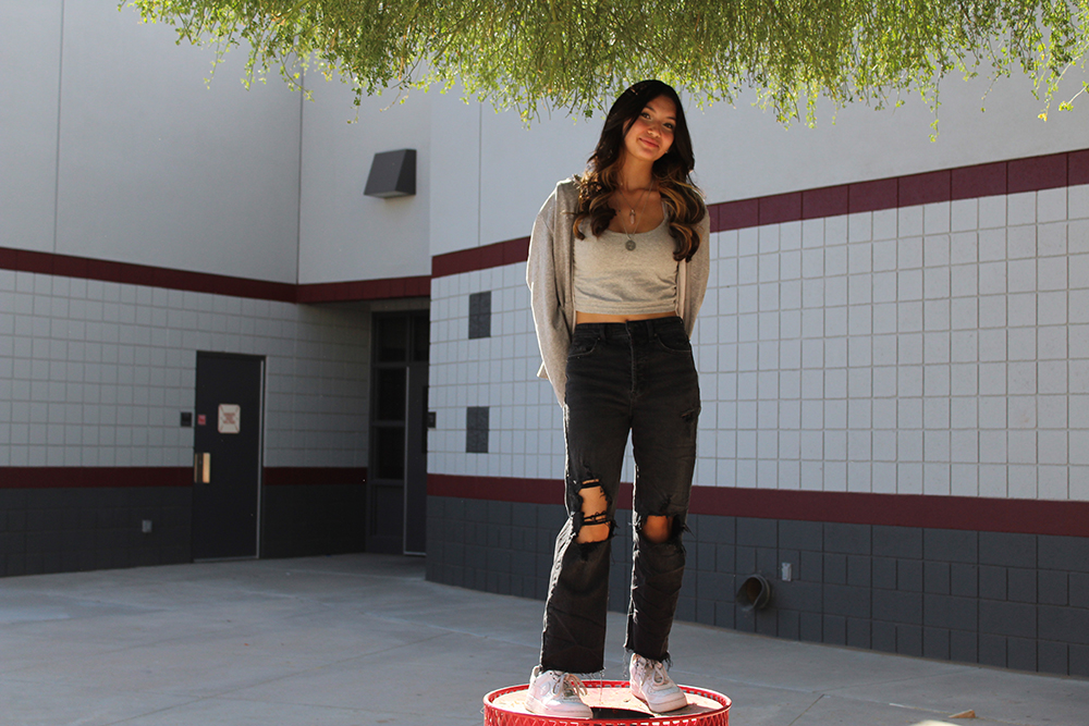 Ethina standing on a trashcan.