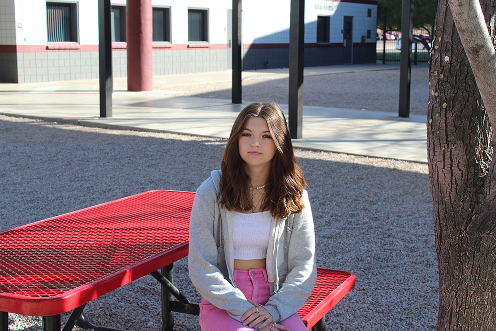 Madison sitting on a bench in the courtyard.