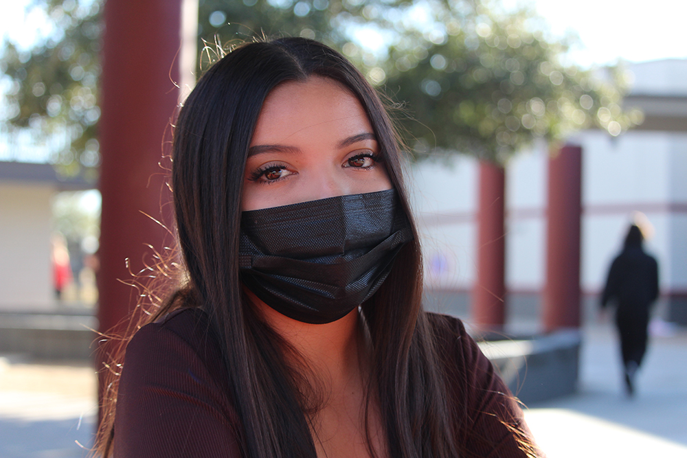 girl with mask sitting on the bench